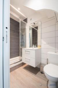 La salle de bains blanche est pourvue de toilettes et d'un lavabo. dans l'établissement Appartement au cœur de Cancale, à Cancale