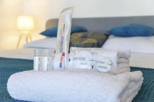 un mucchio di asciugamani e spazzolini da denti in una camera d'albergo di Le Salmson - Studio proche gare a Laval