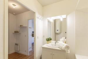 bagno bianco con lavandino e specchio di Le Salmson - Studio proche gare a Laval