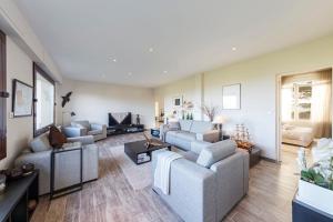 a living room with two couches and a tv at Appartement vue sur la baie de St Briac in Saint-Briac-sur-Mer