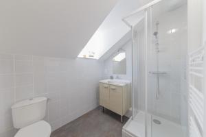 een witte badkamer met een toilet en een douche bij LE MONKEY- 10min à pied de la Gare in Laval