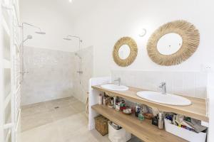a bathroom with two sinks and two mirrors at La Familia - Maison chaleureuse in Laval
