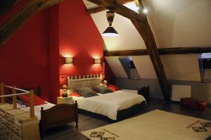 a bedroom with a bed and a red wall at Escale en Charolais Brionnais in Saint-Julien-de-Civry
