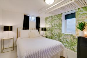 ein Schlafzimmer mit einem weißen Bett und einer Blumentapete in der Unterkunft Cozy and Chic Minneapolis Home 5 Mi to Dtwn! in Minneapolis