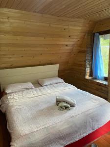 1 dormitorio con 1 cama en una cabaña de madera en bujtina 2, en Valbonë