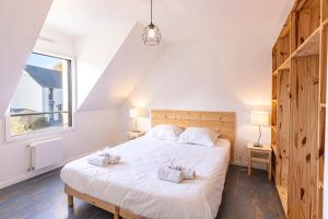 1 dormitorio con 1 cama blanca grande y 2 toallas en Pavillon d'Emeraude, en Saint-Lunaire