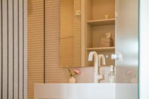 a bathroom with a sink and a mirror at Villa Astoria - Suiten am Meer in Kühlungsborn