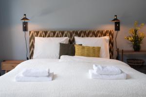 a bedroom with a white bed with two towels on it at Six Boutique Hotel in Haarlem