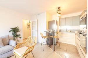 a kitchen with a couch and a table and chairs at La Kloserie appartement en résidence in Saint Malo