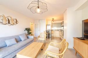 a living room with a couch and a table at La Kloserie appartement en résidence in Saint Malo