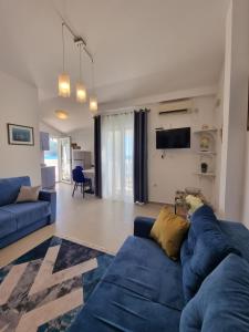 a living room with a blue couch and a tv at Apartments Villa Marija in Petrovac na Moru