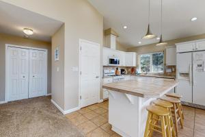 a kitchen with white cabinets and a counter with stools at Beach Escape in Rockaway Beach