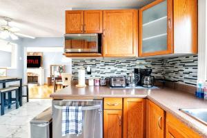 a kitchen with wooden cabinets and a counter top at Comfy Getaway - Walk to West Ed Mall in Edmonton