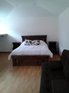 1 dormitorio con 1 cama y 1 sofá en Apartaestudios La Candelaria, en Bogotá