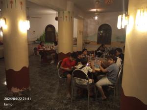 un grupo de personas sentadas en una mesa en un restaurante en oasis panorama en Mandīshah