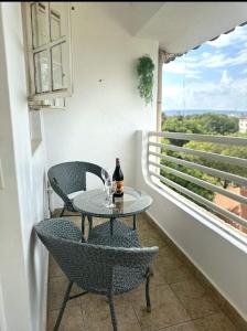 a table with two chairs and a bottle of wine on a balcony at KilimanjaroHansel 1 BR with AC and Backup Gen in Kisumu
