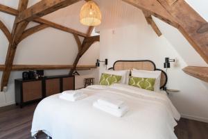 a bedroom with a white bed with towels on it at Six Boutique Hotel in Haarlem