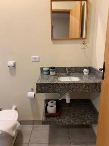 La salle de bains est pourvue d'un lavabo et d'un miroir. dans l'établissement Studio Standard l AO LADO SHOPPING, à Três Lagoas