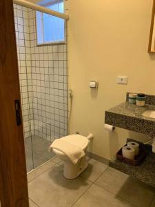 La salle de bains est pourvue d'une douche et de toilettes. dans l'établissement Studio Standard l AO LADO SHOPPING, à Três Lagoas