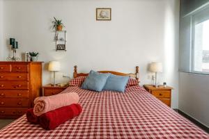 a bedroom with a bed with a red and white checked spread at Casa Jansiver - 450m de la playa, céntrica pero tranquila in Los Alcázares