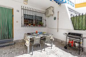 a patio with a table with chairs and a grill at Casa Jansiver - 450m de la playa, céntrica pero tranquila in Los Alcázares