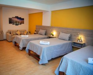 um quarto de hotel com duas camas e um sofá em HOTEL SUDAMERICANA INN em Tacna