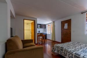 a bedroom with a couch and a bed and a kitchen at Apartaestudios La Candelaria in Bogotá