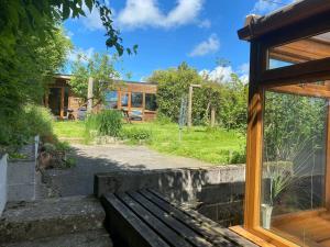 un banc en bois assis devant une maison dans l'établissement Quirky Cottage with Private Garden Nr New Quay Cardigan Bay, à Llandysul