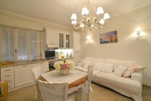 ein Wohnzimmer mit einem weißen Sofa und einem Tisch in der Unterkunft CASA GRANDIS Dimora di Charme nel Cuore di Bordighera in Bordighera