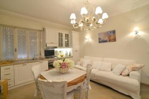salon z białą kanapą i stołem w obiekcie CASA GRANDIS Dimora di Charme nel Cuore di Bordighera w mieście Bordighera