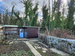 a small shed with a blue door in a garden at Chalet avec jardin proche de Disneyland in Chalifert