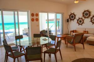 una sala de estar con mesa y sillas y el océano en Nisiros Spacious Beachfront home, en Chicxulub