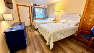 um quarto de hotel com duas camas e uma cadeira em The Lamplight Inn em Lavallette