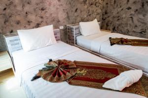 duas camas num quarto com uma bandeja na cama em Buengngarm Resort 