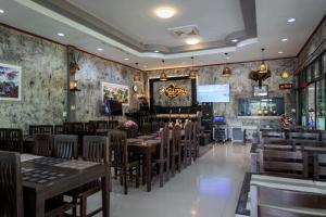 un restaurant avec des tables et des chaises en bois ainsi qu'un bar dans l'établissement Buengngarm Resort, 