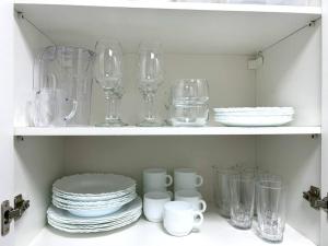 a shelf filled with glasses and plates and dishes at Oásis Urbano - Expo Center Norte in Sao Paulo