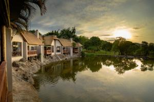 grupa domów obok zbiornika wodnego w obiekcie Umbhaba Eco Lodge w mieście Hazyview