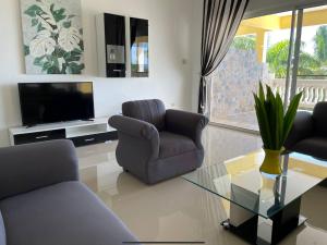 a living room with two chairs and a television at Spring Garden Mobay Resort in Montego Bay