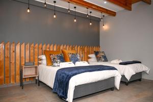- une chambre avec 2 lits et un mur en bois dans l'établissement Hartklop, à Kimberley
