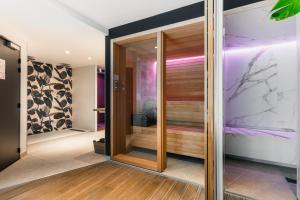 a pivot door in a hallway with wood panels at Le Cornouaille Hotel & Spa in Bénodet