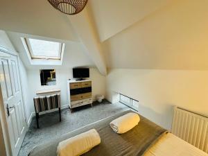 a bedroom with a bed and a tv and a window at West Street Mews - Serviced Accommodation in Exeter