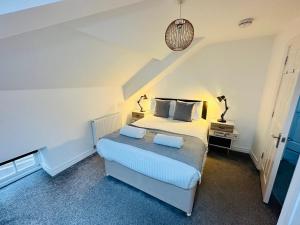 a bedroom with a bed with two lamps on it at West Street Mews - Serviced Accommodation in Exeter
