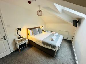 a bedroom with a large bed and a roof at West Street Mews - Serviced Accommodation in Exeter