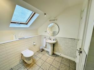 a bathroom with a sink toilet and a window at West Street Mews - Serviced Accommodation in Exeter