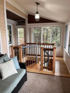 uma sala de estar com uma varanda com um sofá em Storybook Lake Front Villa with Private Beach! em Winchester
