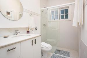 a white bathroom with a toilet and a shower at Secreto Boutique Hotel in Campos do Jordão