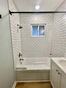 ein weißes Badezimmer mit einer Badewanne und einem Waschbecken in der Unterkunft Cathedral 6-Walk to UNMC in Omaha