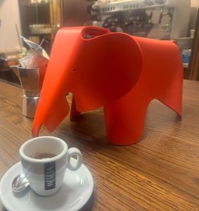 una figurita de elefante junto a una taza de café en Da Noi Trattoria Hotel, en Vergato