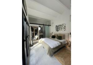 um quarto com uma cama com lençóis brancos e almofadas em Begur, mon amour em Begur