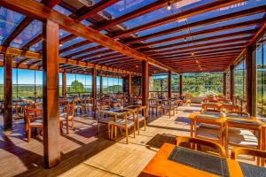 un ristorante con tavoli e sedie in legno e finestre di Laghetto Golden a Gramado